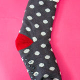 Navy polka dot sherpa-lined cabin socks with red accents and non-slip soles.
