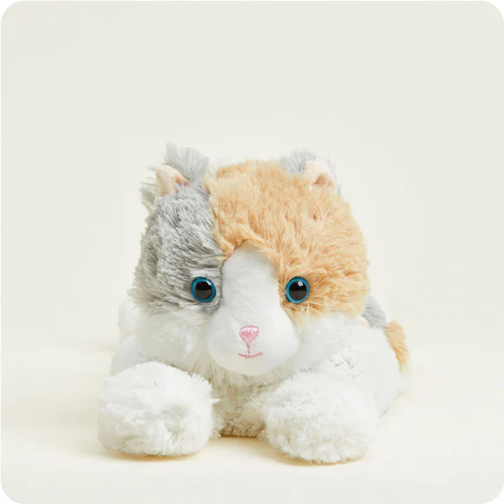 A soft, plush calico cat toy with patches of white, orange, and grey fur, designed to be microwavable.