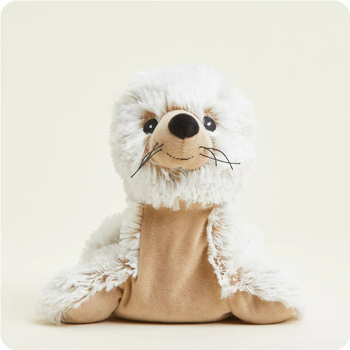 A soft, white plush seal toy with big dark eyes and whiskers, designed to be microwavable.