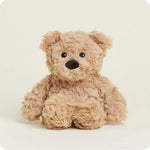 A small, soft plush teddy bear with curly brown fur and a friendly face, designed to be microwavable.