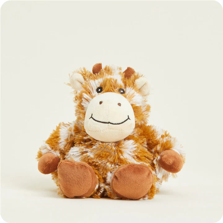 A small, soft plush giraffe toy with a spotted pattern, designed to be microwavable.