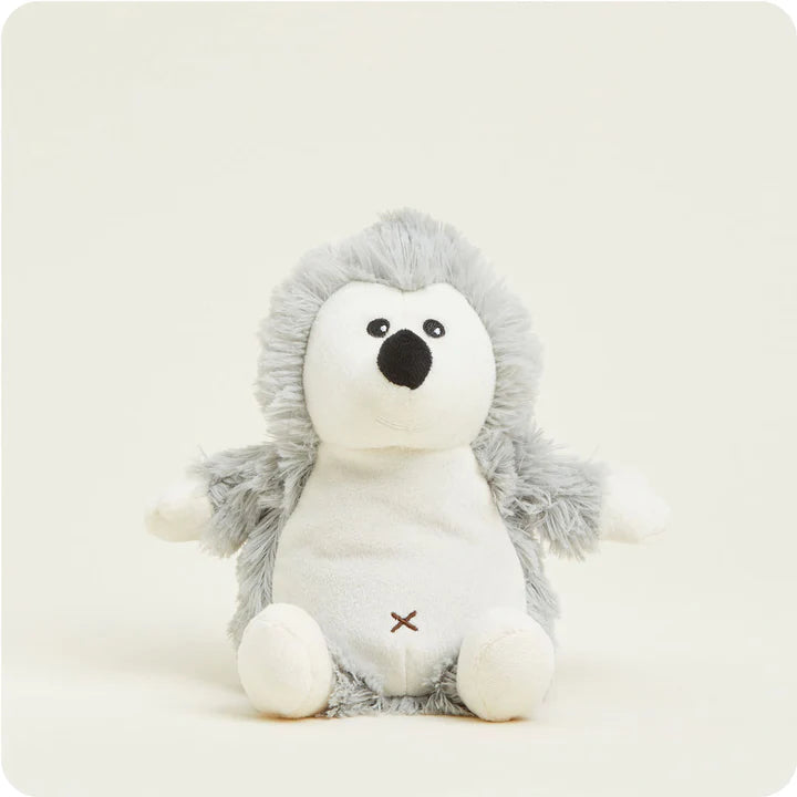 A small, soft plush hedgehog toy with textured grey "spines" and a white face, designed to be microwavable.