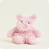 A small, soft pink plush pig toy with a curly tail and snout, designed to be microwavable.