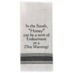 White tea towel with black trim and funny Southern honey quote.